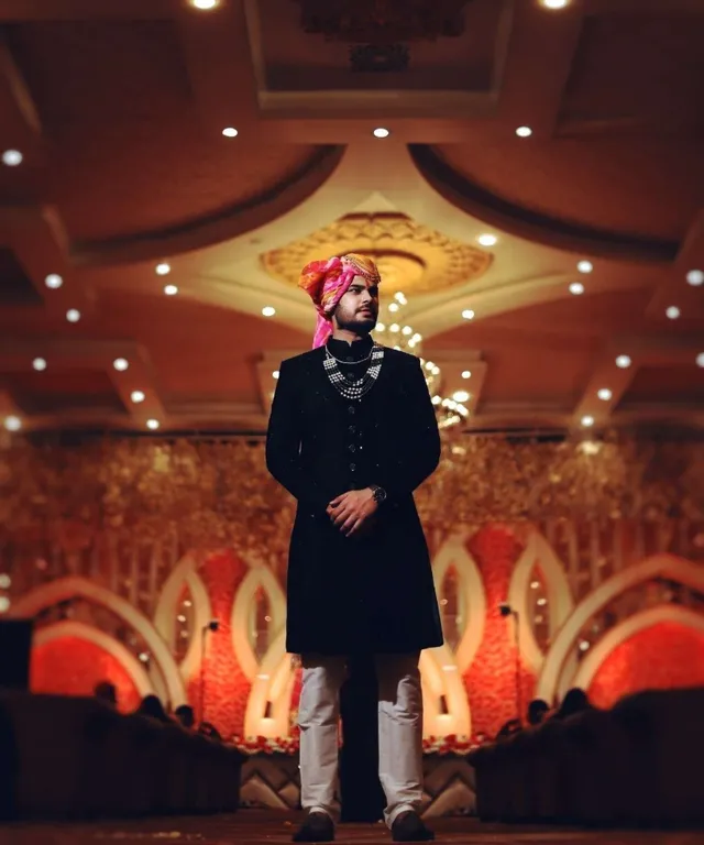 a man in a black outfit standing in a room