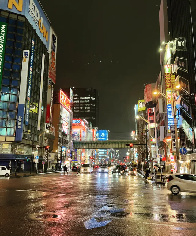 a city street at night with cars and buildings