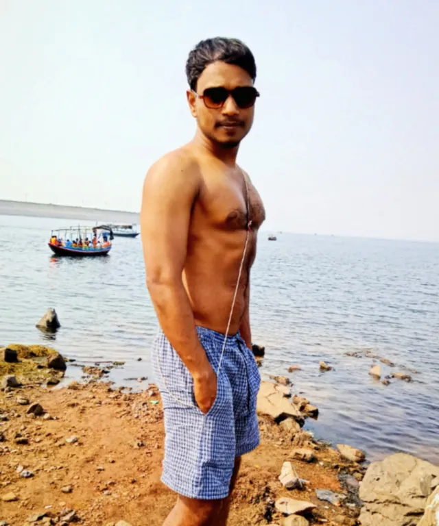 a man standing on a beach next to a body of water