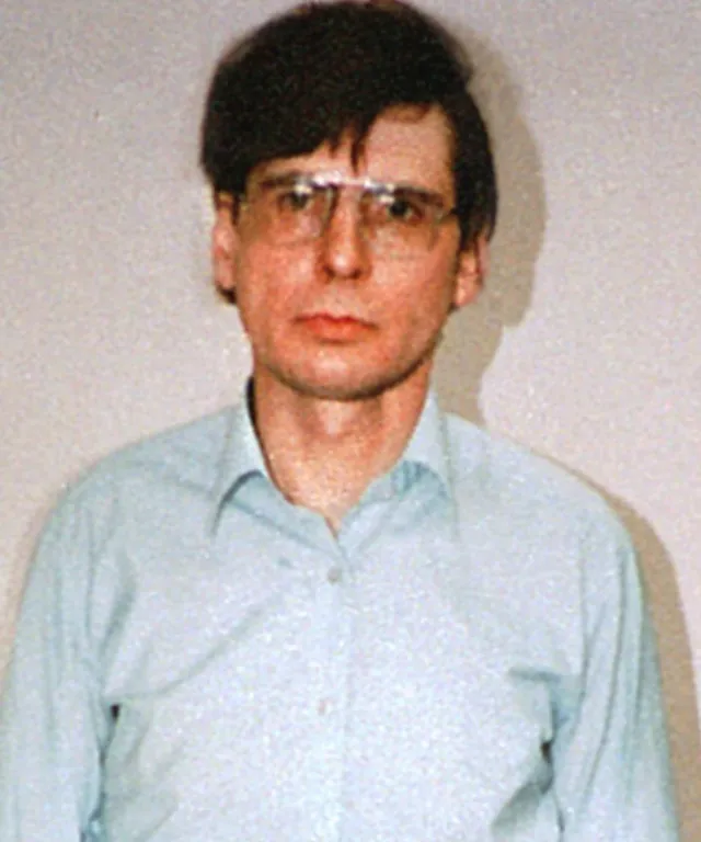 a man wearing glasses and a blue shirt