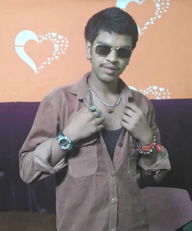 a man in a brown shirt and some bracelets