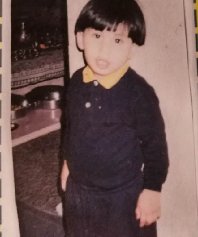 a young boy standing in front of a record player