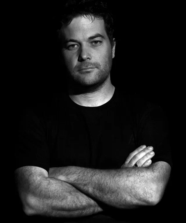 a black and white photo of a man with his arms crossed