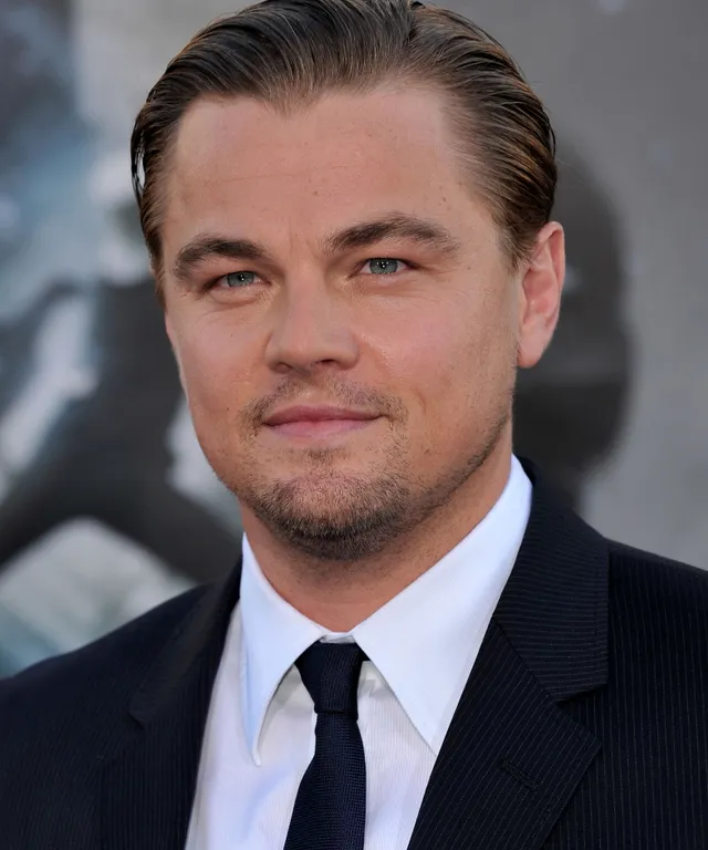 a close up of a person wearing a suit and tie