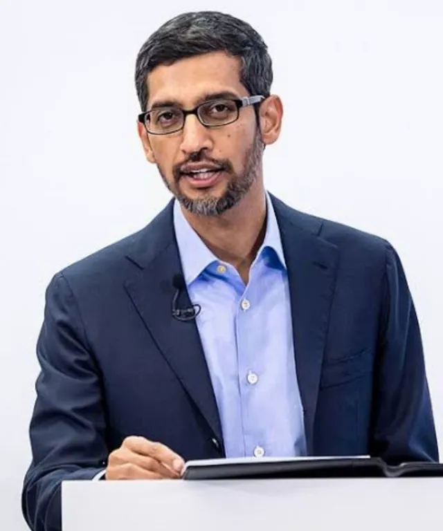 a man in a suit and glasses giving a speech