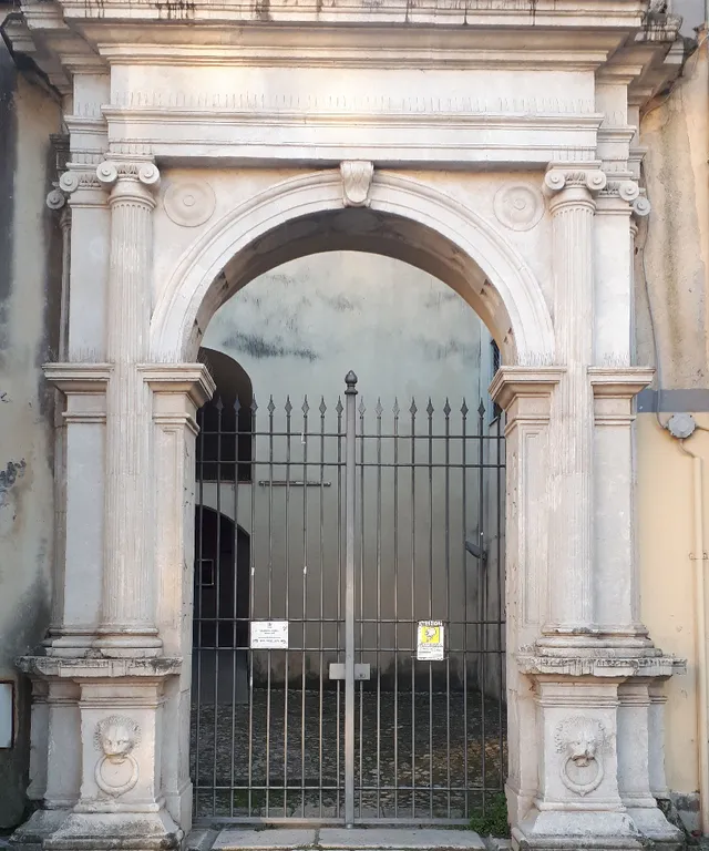 an old building with a gate and a sign on it