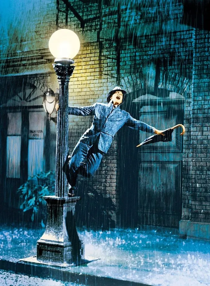 a man is jumping in the rain on a lamp post