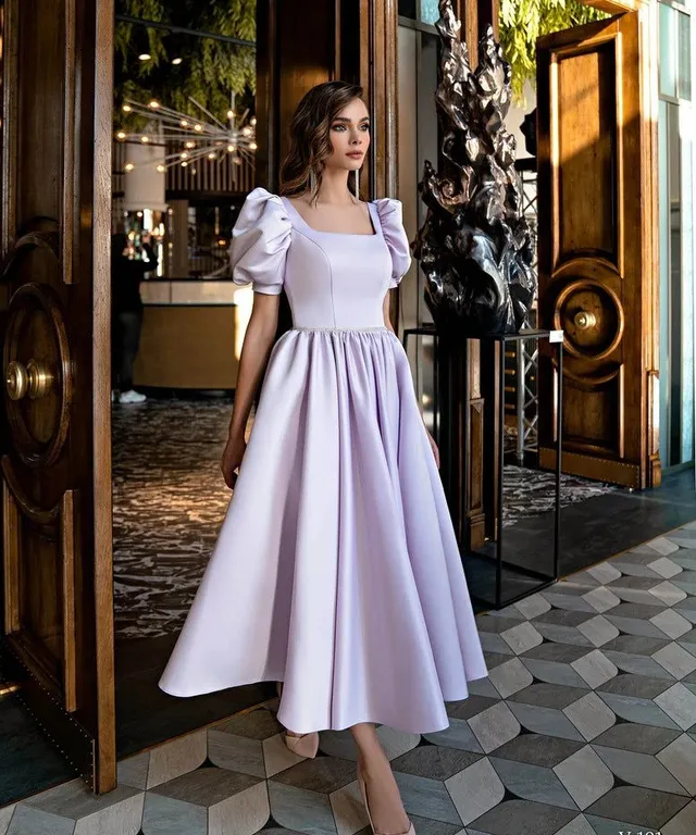 a woman standing in front of a door wearing a dress
