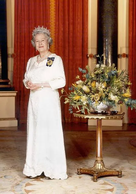 Queen elizabeth in a white dress standing in a room