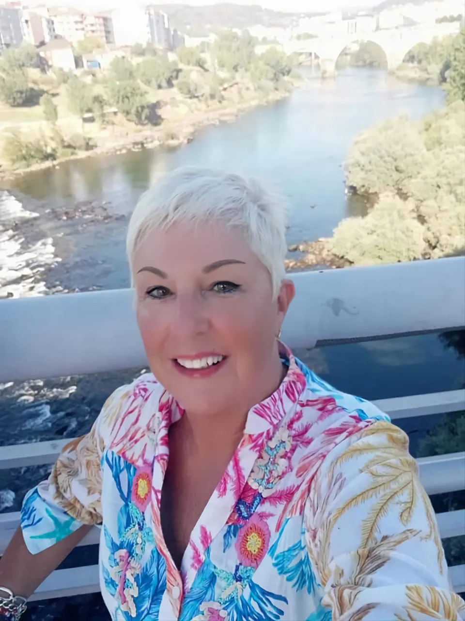 a woman sitting on a bench with a river in the background