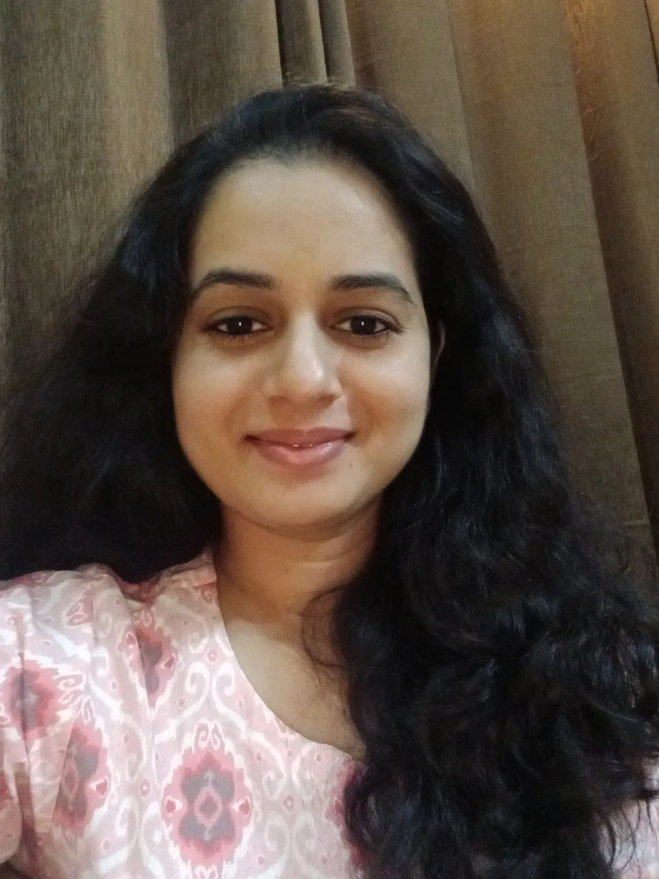 a woman with long black hair smiling for the camera