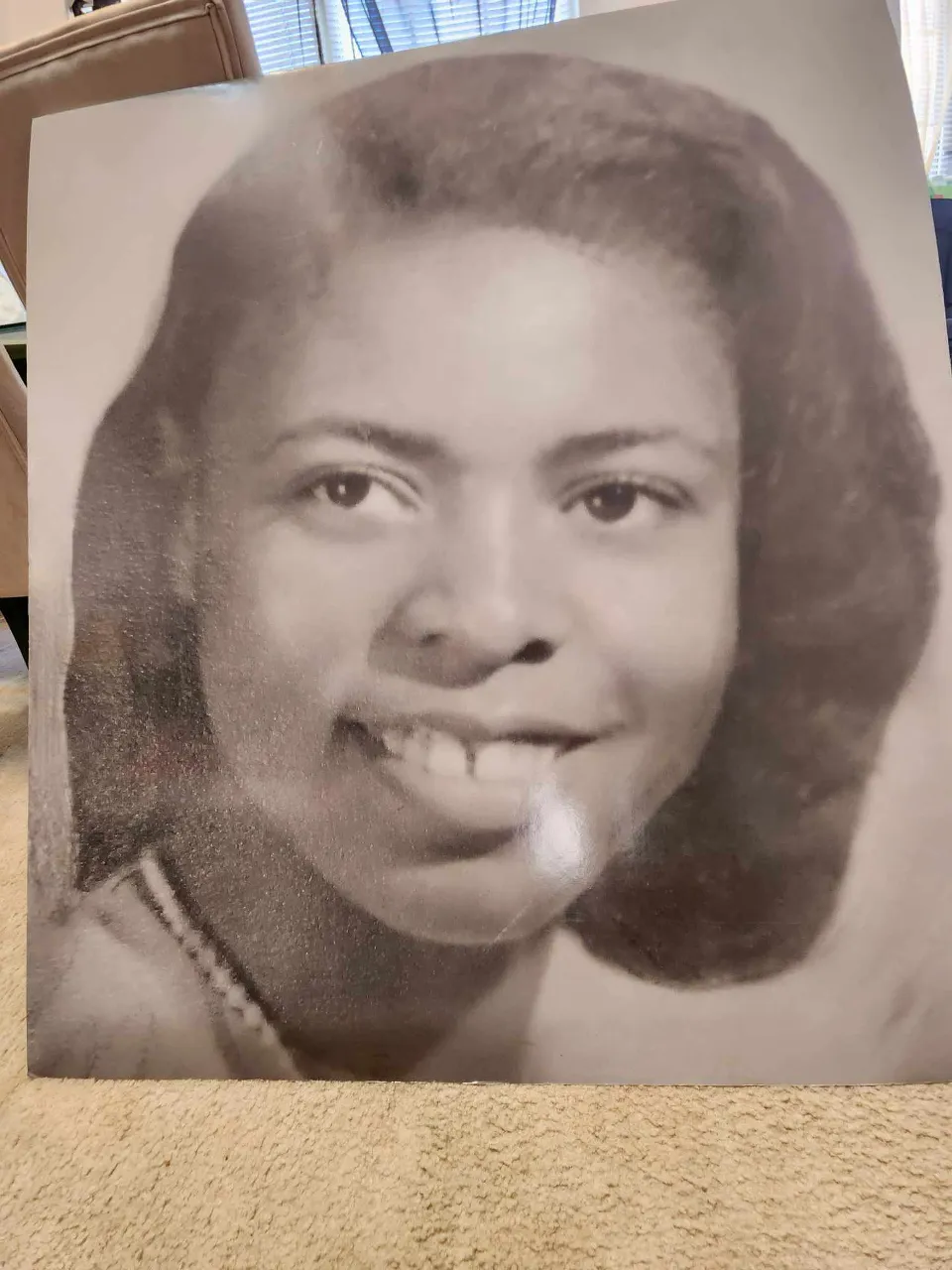 a black and white photo of a african american smiling woman