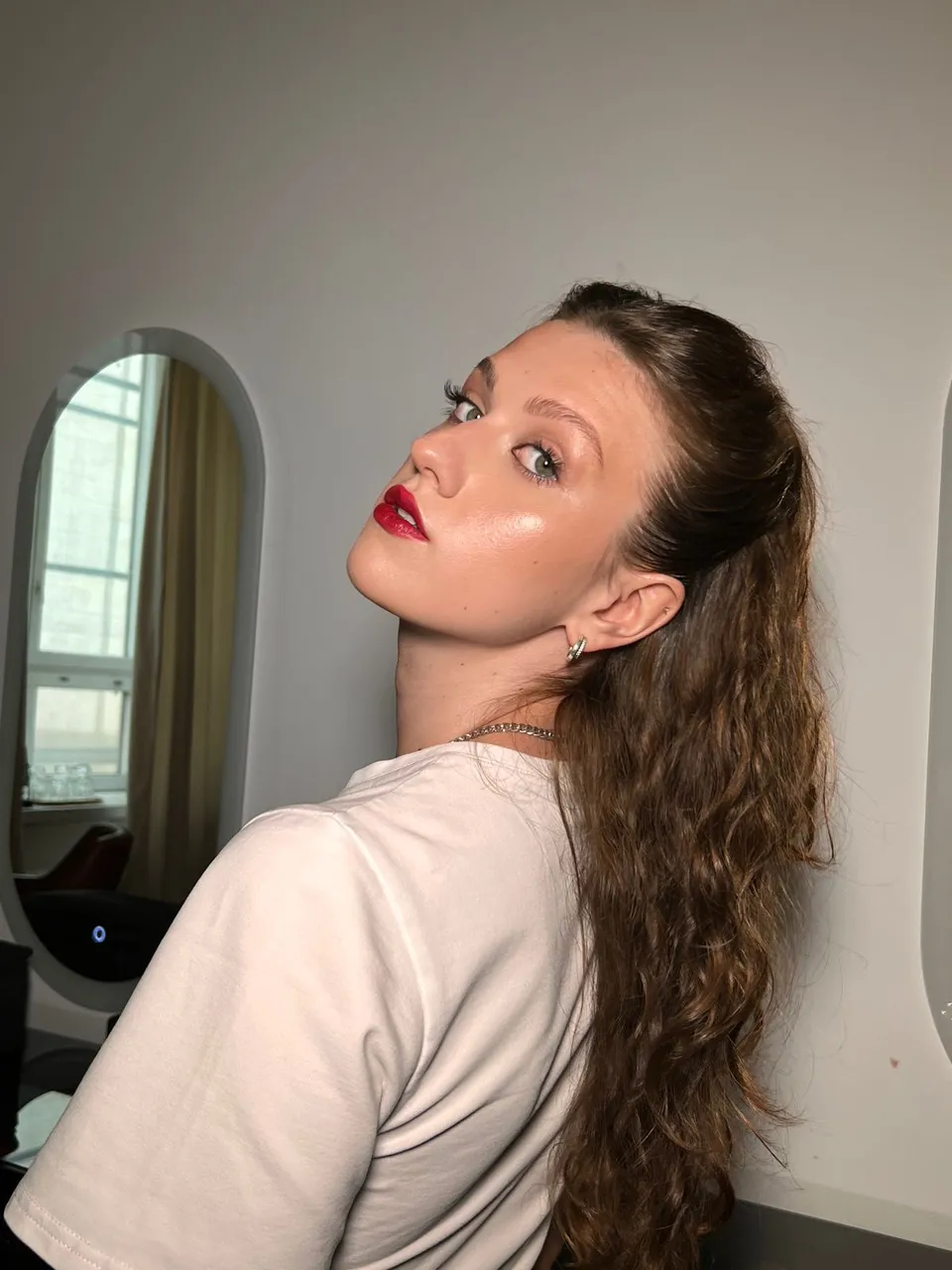 a woman with long hair wearing a white shirt