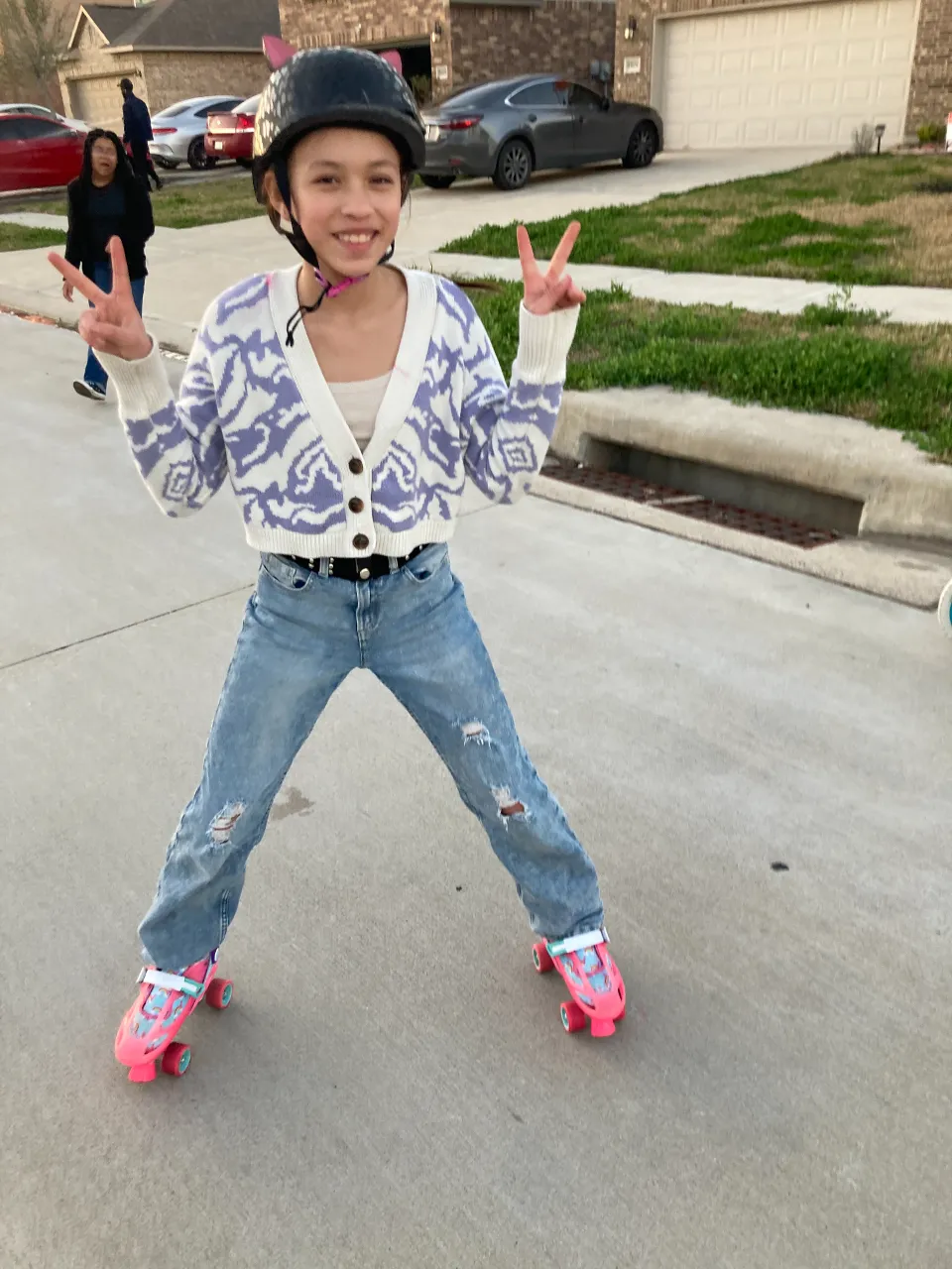 a young girl riding a skateboard down a street