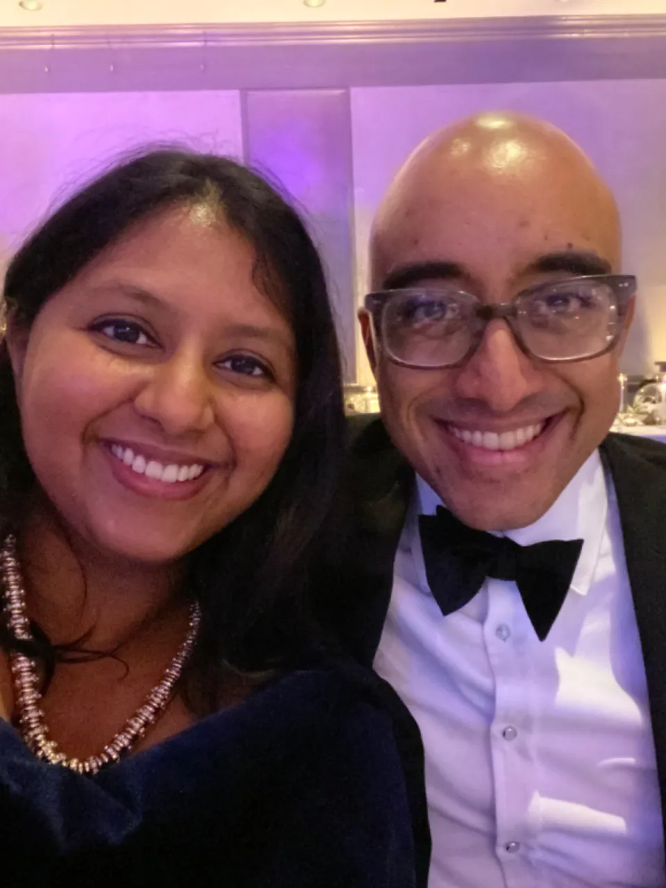 a man and a woman posing for a picture in black tie attire