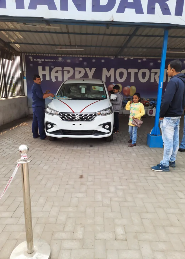 a group of people standing around a white car