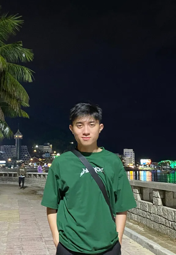 a man in a green shirt standing next to a palm tree