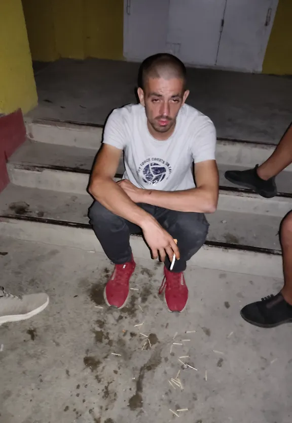 a man sitting on the steps smoking a cigarette