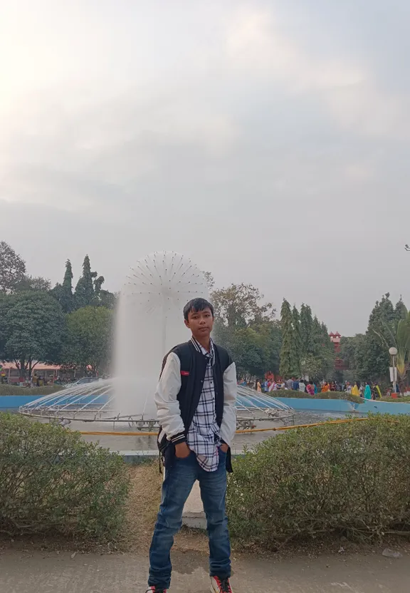 A man stands in front of a fountain, with a figure in the background that resembles a stereotypical Mexican gunmen. Add a figure in the background