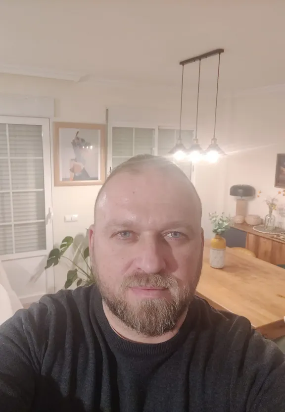 a man with a beard sitting in a living room