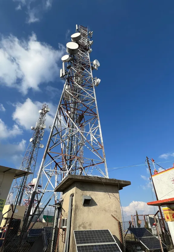 a cell tower with solar panels on top of it