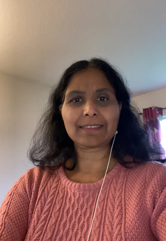 a woman in a pink sweater taking a selfie