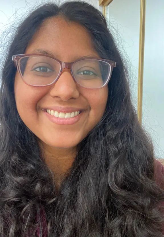 a woman in glasses smiling for the camera