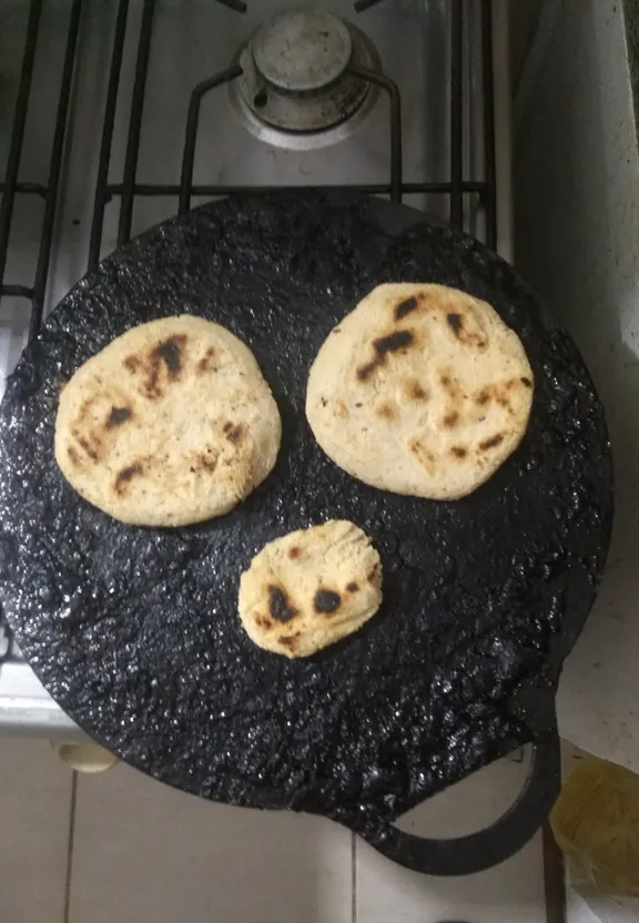 three tortillas are being cooked in a cast iron pan