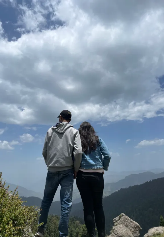 a man and a woman standing on top of a mountain