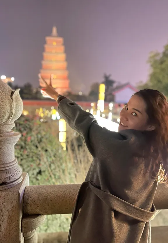 a woman in a robe is leaning on a fence