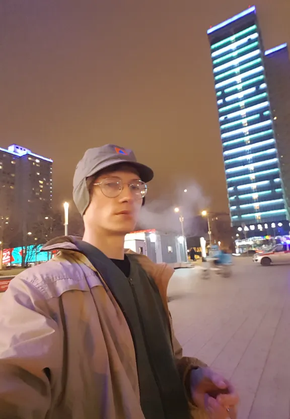 a man standing in front of a tall building