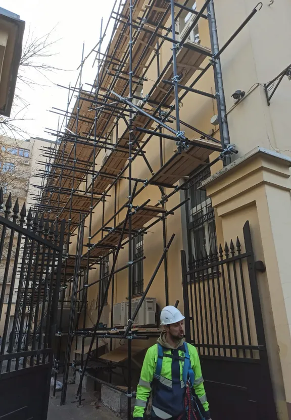 a man standing in front of a building with scaffolding on it