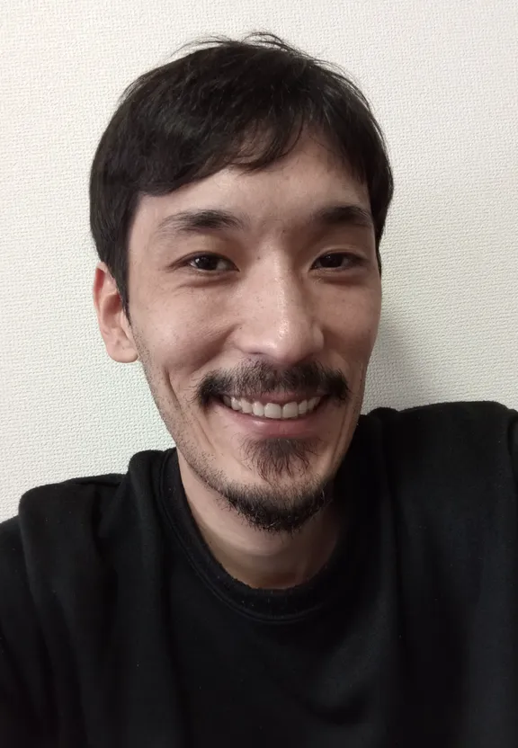 a man with a mustache smiling for the camera