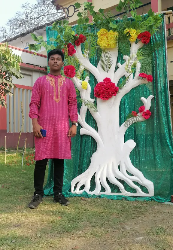 a man standing in front of a fake tree