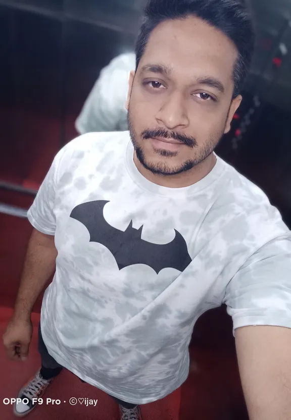 a man with a mustache and a batman t - shirt