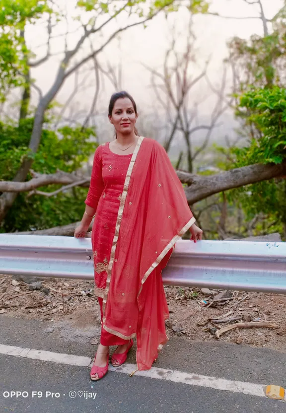 a woman in a red dress standing on a road