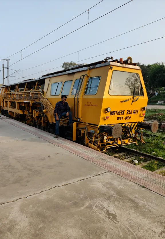 a man sitting on the side of a yellow train