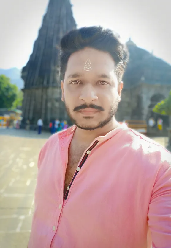 a man in a pink shirt standing in front of a building