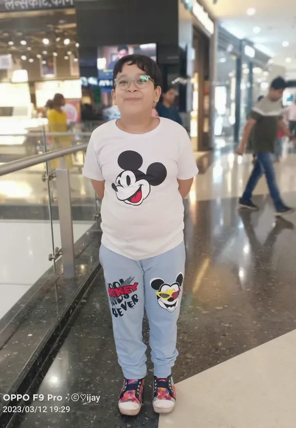 a young boy wearing a mickey mouse t - shirt