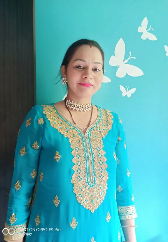 a woman standing in front of a blue wall