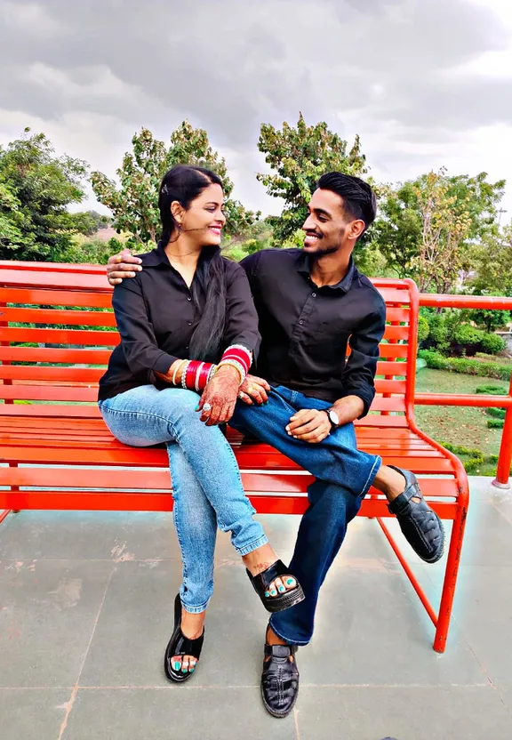 a man and a woman sitting on a red bench