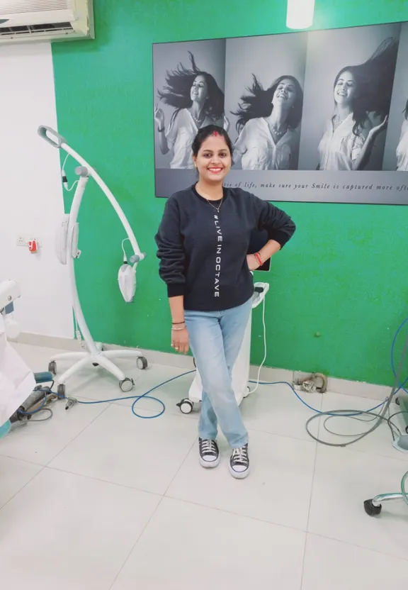 a woman standing in front of a green wall