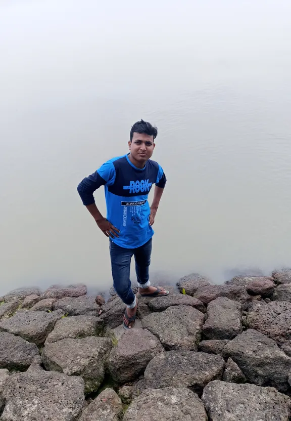 a man standing on rocks near the water