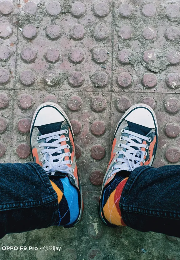 a pair of feet with colorful sneakers on