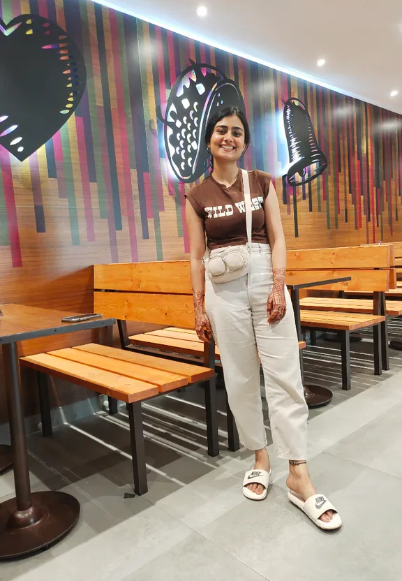 a woman standing in front of a colorful wall