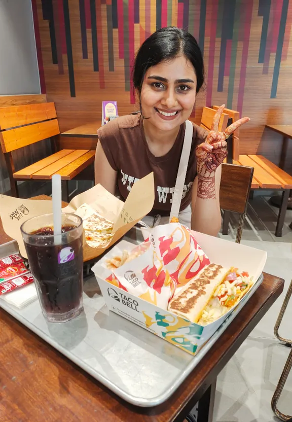 a woman sitting at a table with a plate of food