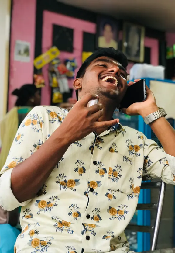 a man sitting in a chair talking on a cell phone