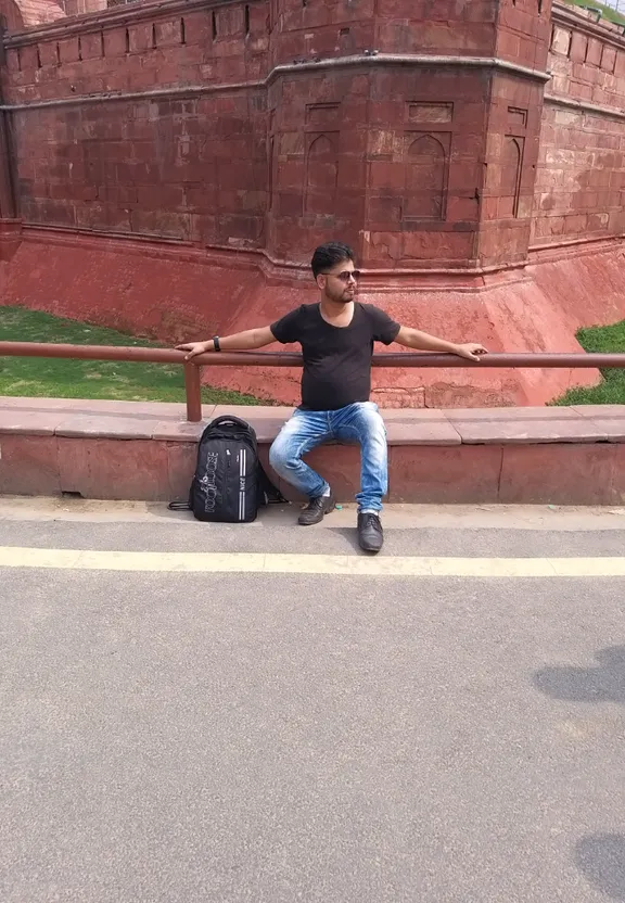 a man sitting on a bench next to a suitcase