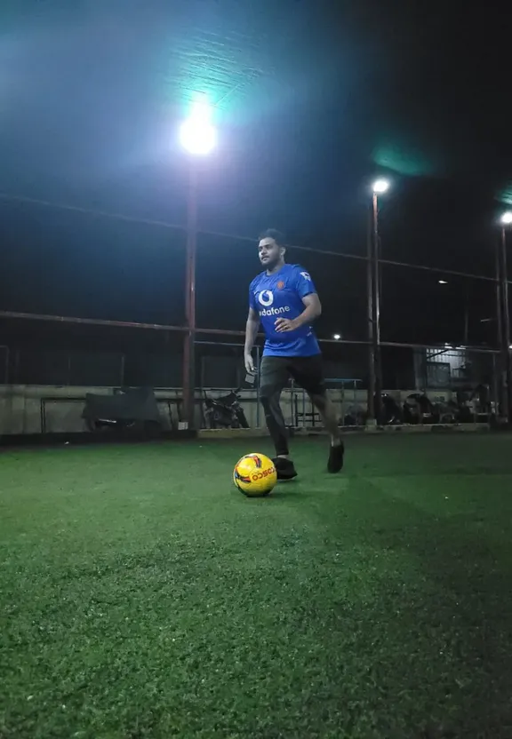 a man standing next to a soccer ball on a field