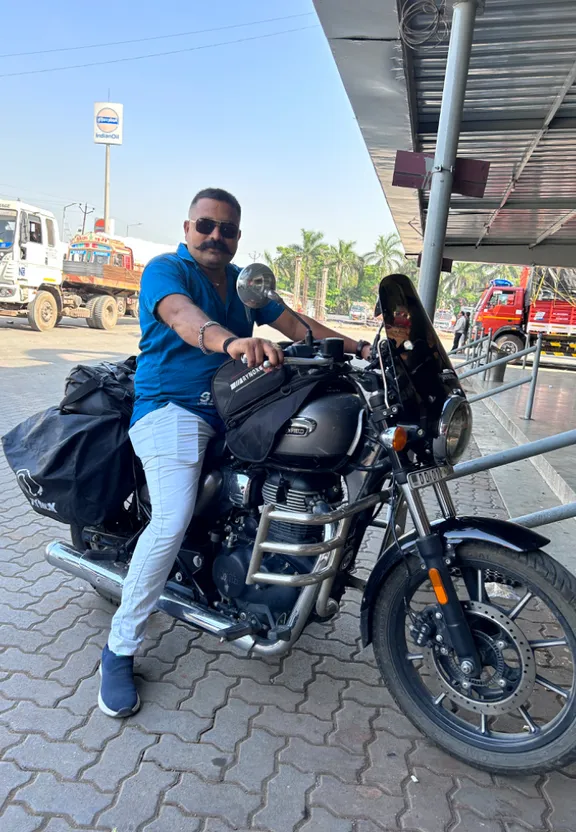 a man sitting on a motorcycle at a gas station